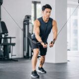 ハイ・トゥ・ローのケーブルクロスオーバーを行う男性