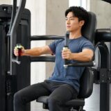 チェストプレスマシンを正しいフォームで押す男性