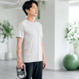 握力計を体につけず腕を自然に下げて測定する男性