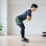 股関節を後ろへ引いてヒップヒンジを行う男性