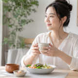 生理中に温かい飲み物とバランスのよい食事を取る女性