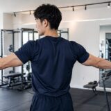 ケーブルで三角筋後部を鍛える男性