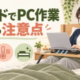 ベッド上で安定した台と背中の支えを使い短時間作業する人