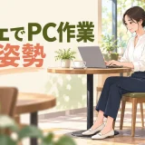 カフェの机でパソコンを正面に置いて作業する人