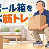 段ボール箱を身体へ近づけて持ち上げる中高年男性