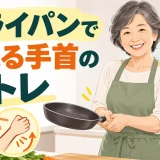 台所でフライパンを両手で安全に持つ中高年女性