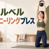 両膝立ちでケトルベルを頭上へ押す人物