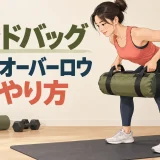前傾姿勢でサンドバッグを腹部へ引く運動