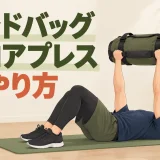 仰向けでサンドバッグを胸上へ押す運動