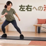 専用ブーティーでスライドボード上を短く横へ滑る様子