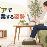 ソファで腰と足を支え、台に置いたパソコンを使うデスクワーカー