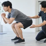 スクワットで上体が前傾するフォームを確認する様子