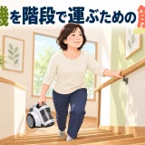 手すりを使い軽量掃除機を階段で運ぶ中高年女性