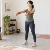 リストウェイトで腕上げ運動を行う女性